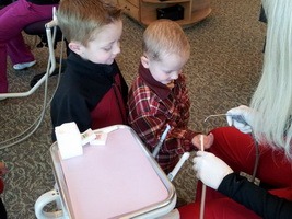 Young kids looking at a dental instrument