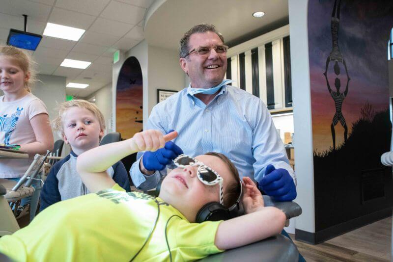 Pediatric dentist in Centerville smiling with three young patients